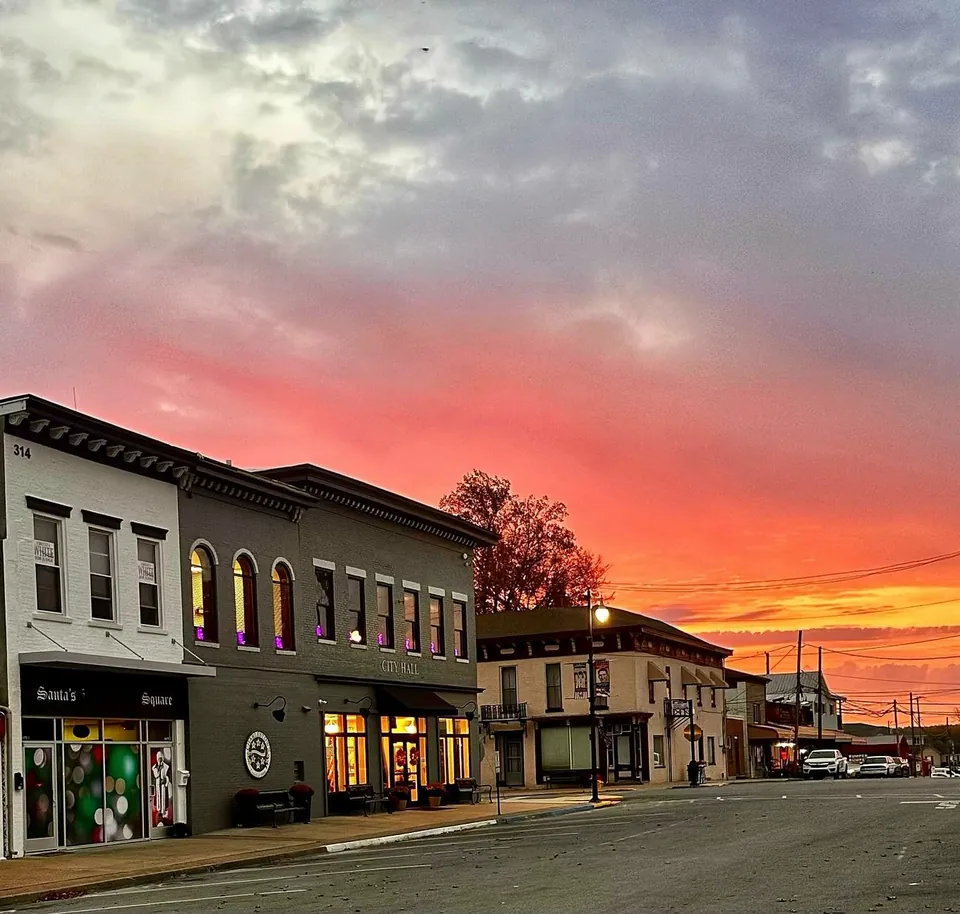 Small-town main street at sunset with a brick City Hall building