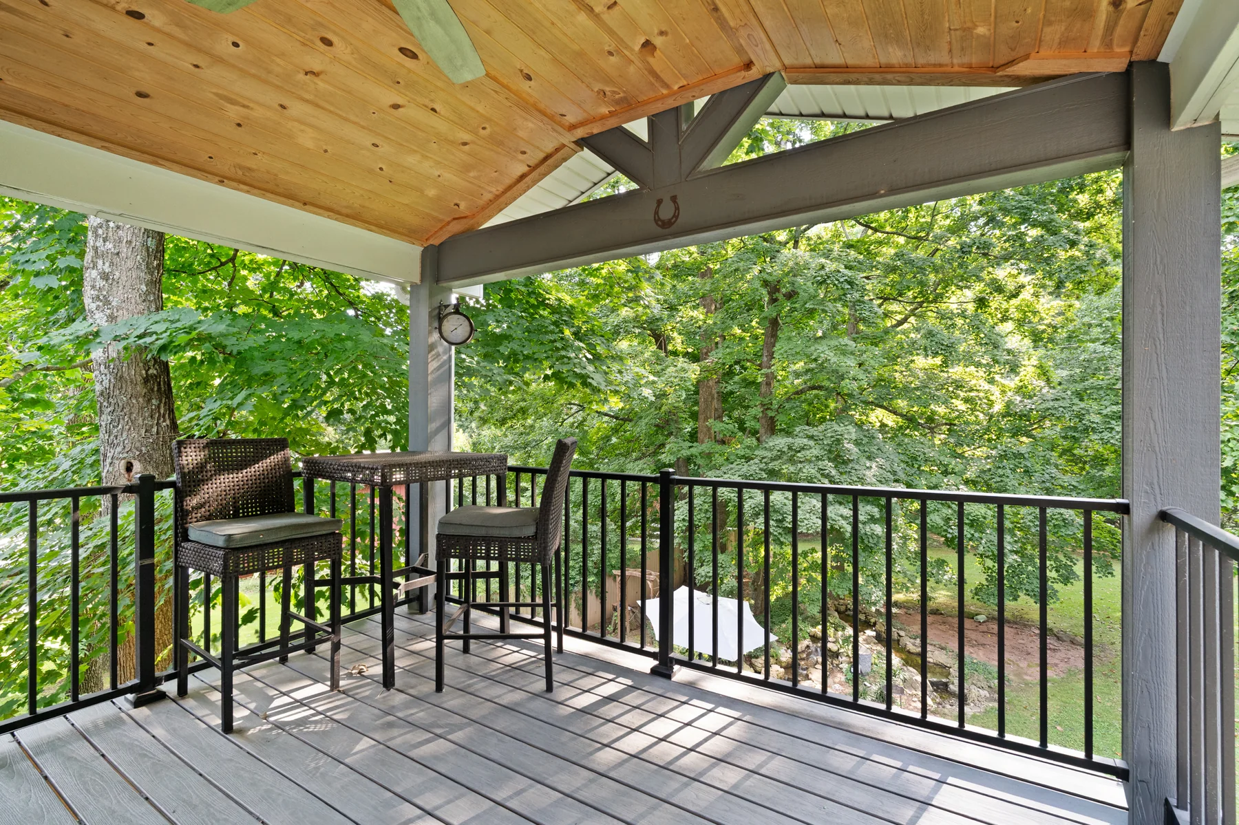 Covered private porch surrounded by mature trees