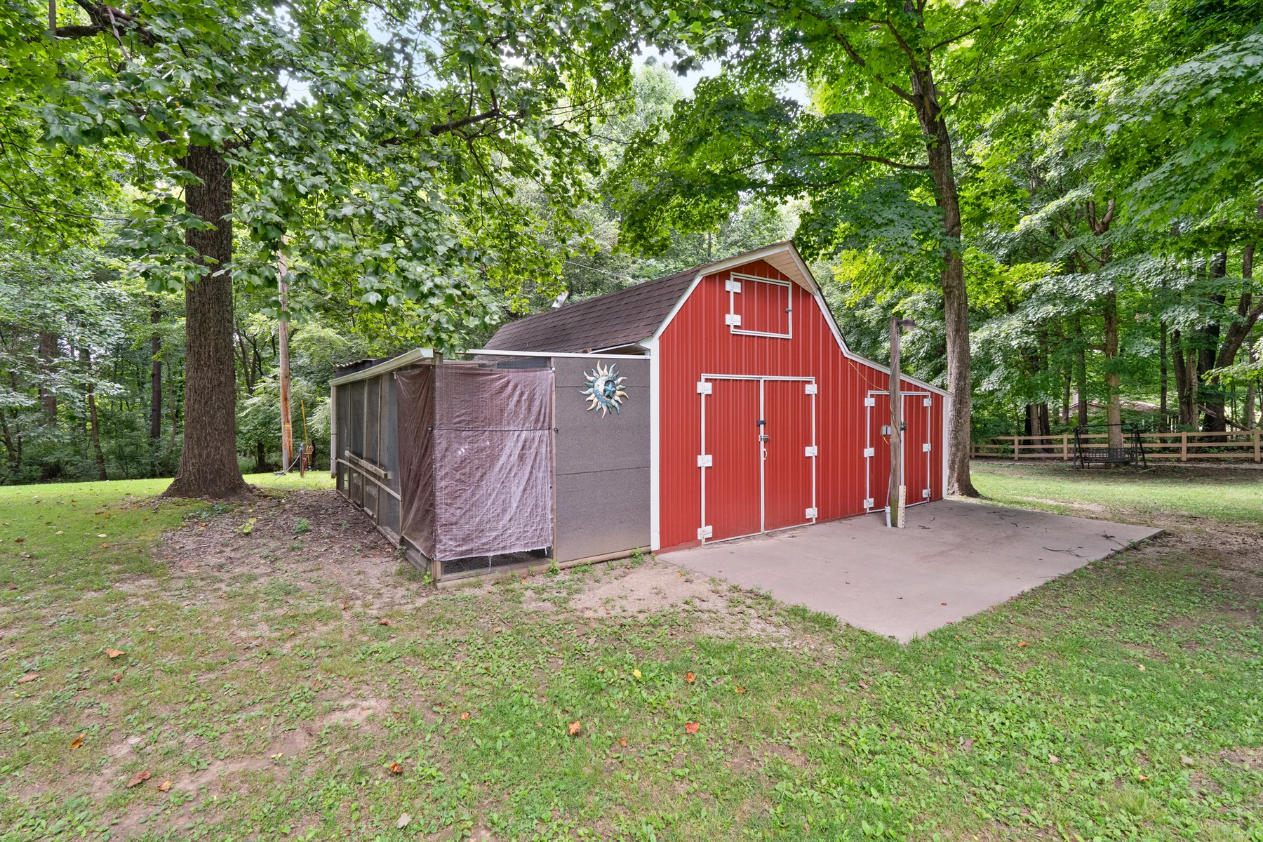 Red barn among mature trees on the property