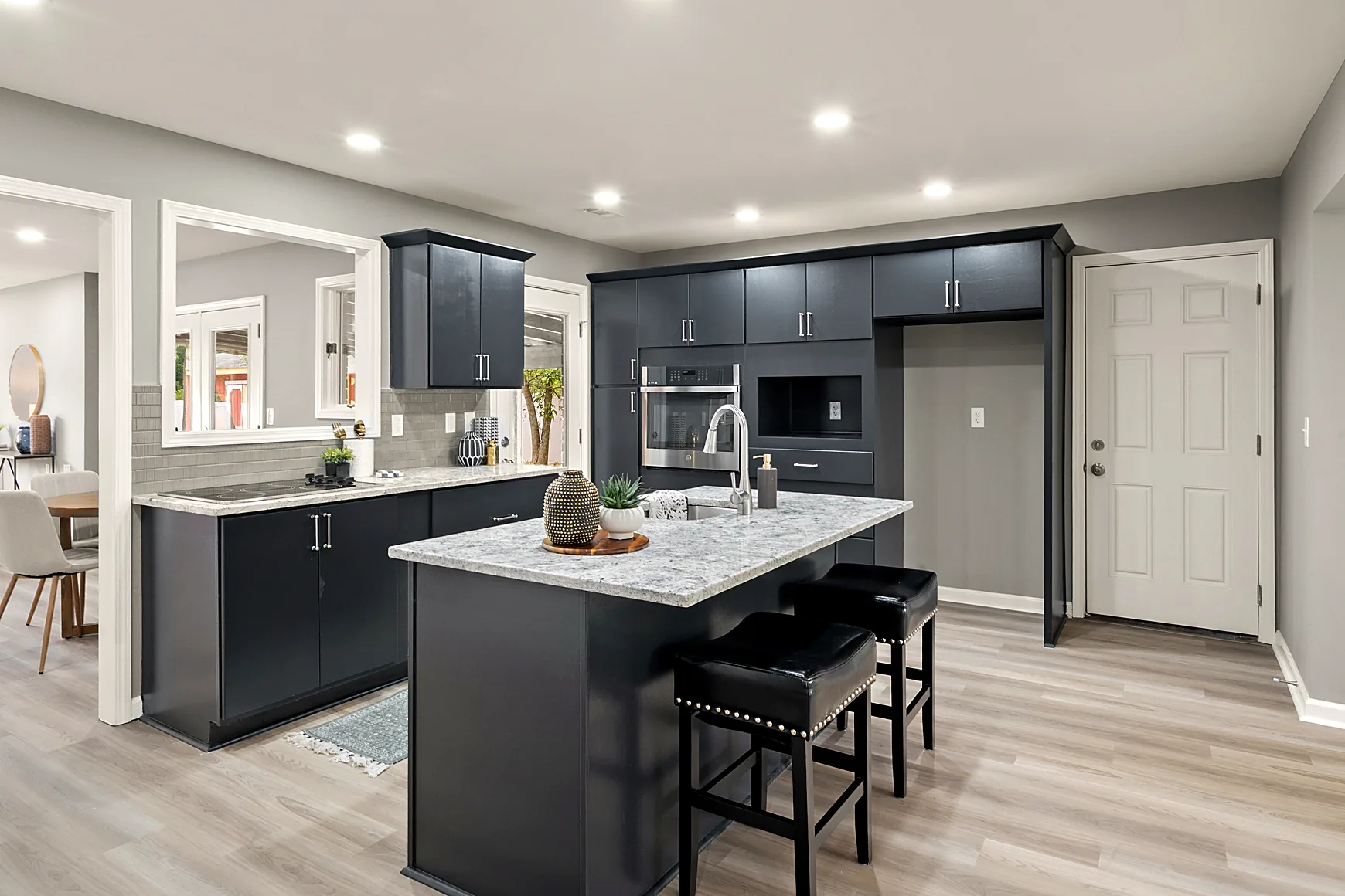 Updated kitchen with granite countertops, subway tile backsplash, and a large island