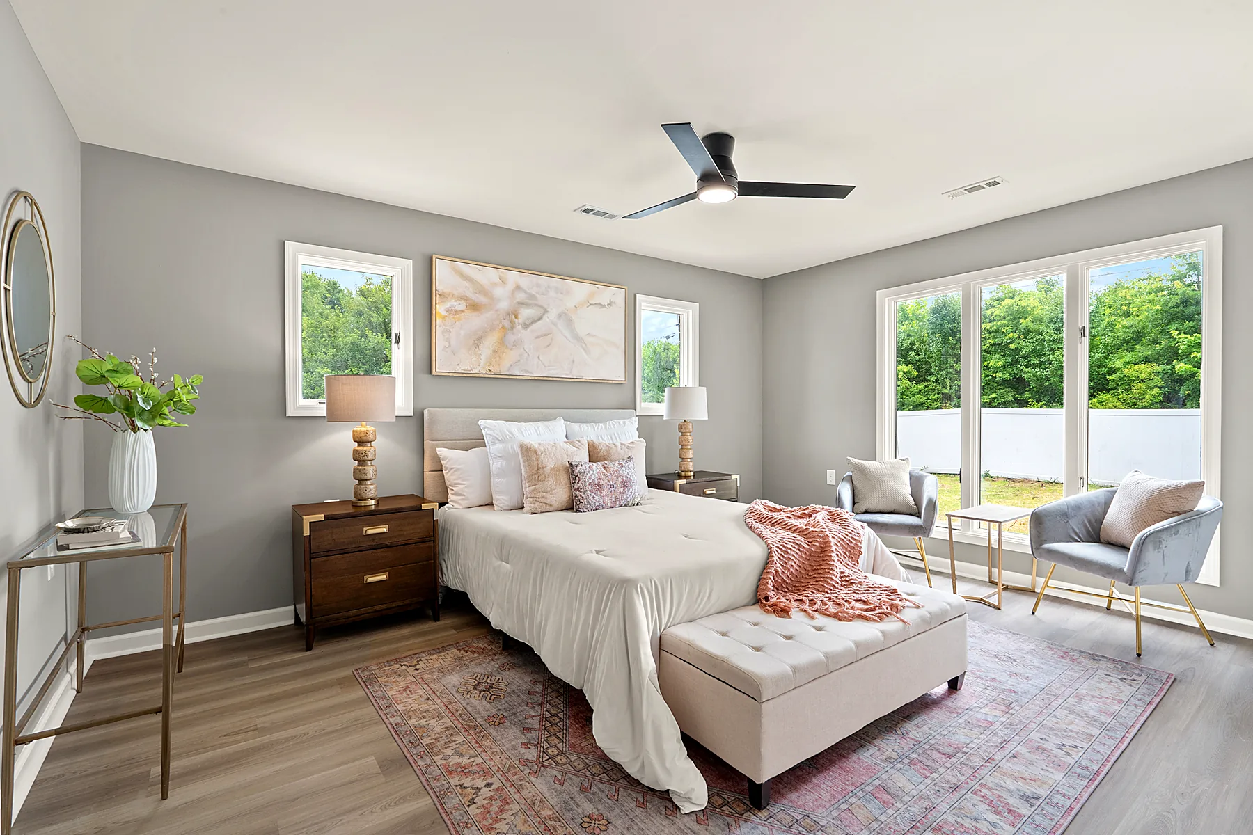 Main-level primary bedroom with neutral walls and a ceiling fan