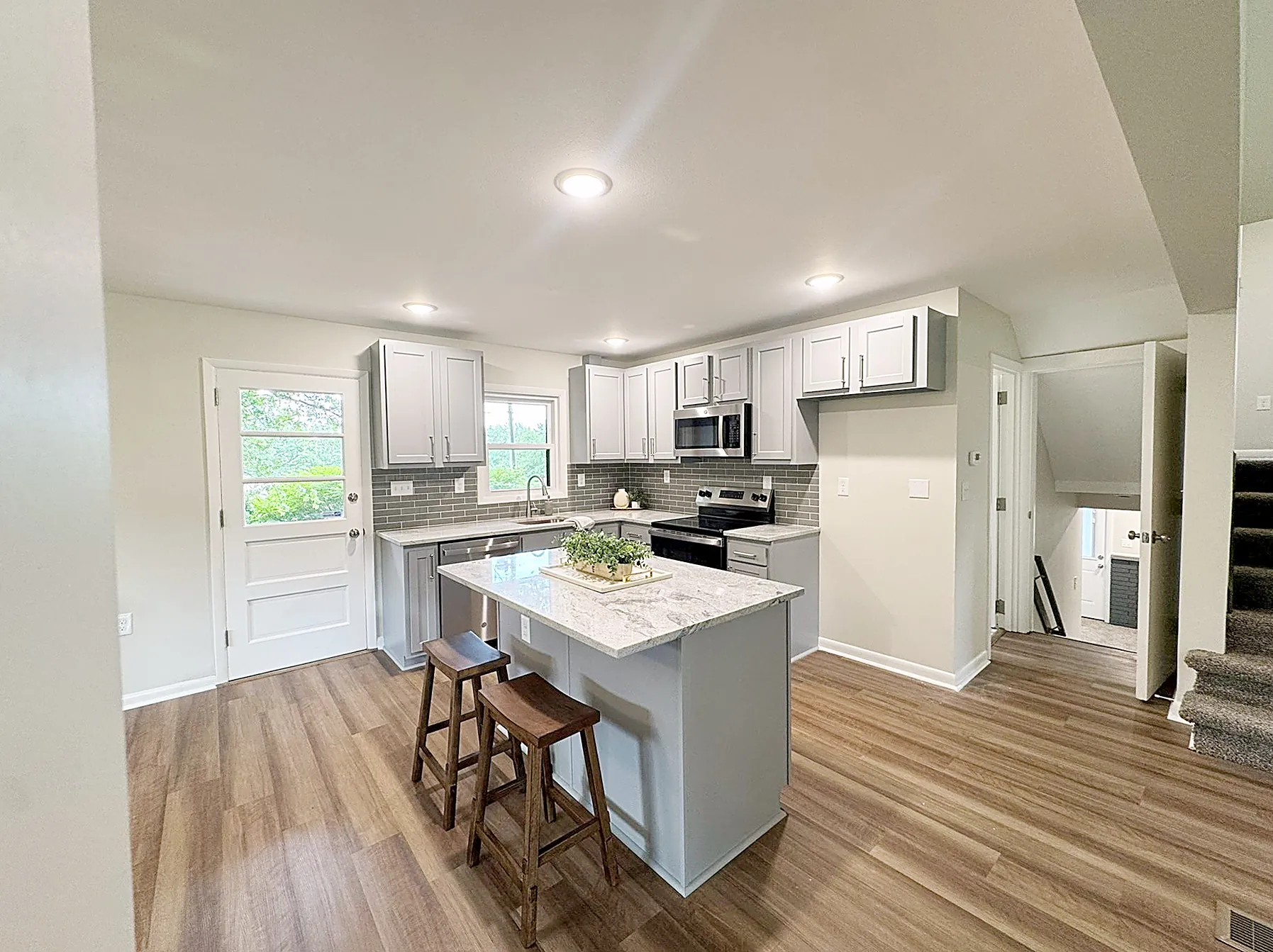 Kitchen detail with stainless appliances, granite counters, and tile backsplash