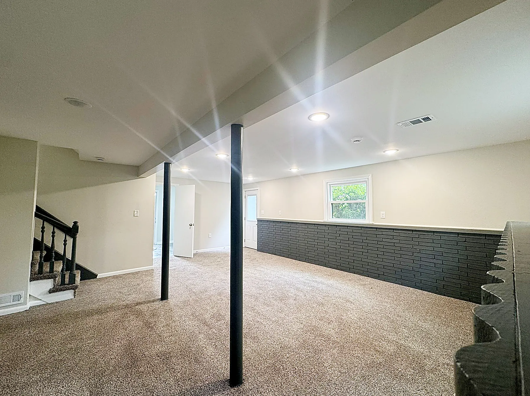 Finished walkout lower-level family room with exterior doors opening to the backyard