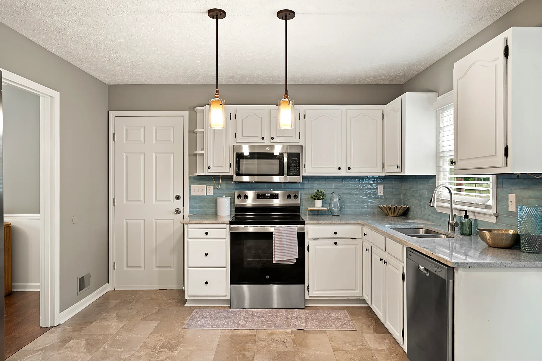 Eat-in kitchen with granite countertops, tile backsplash, and ample cabinetry
