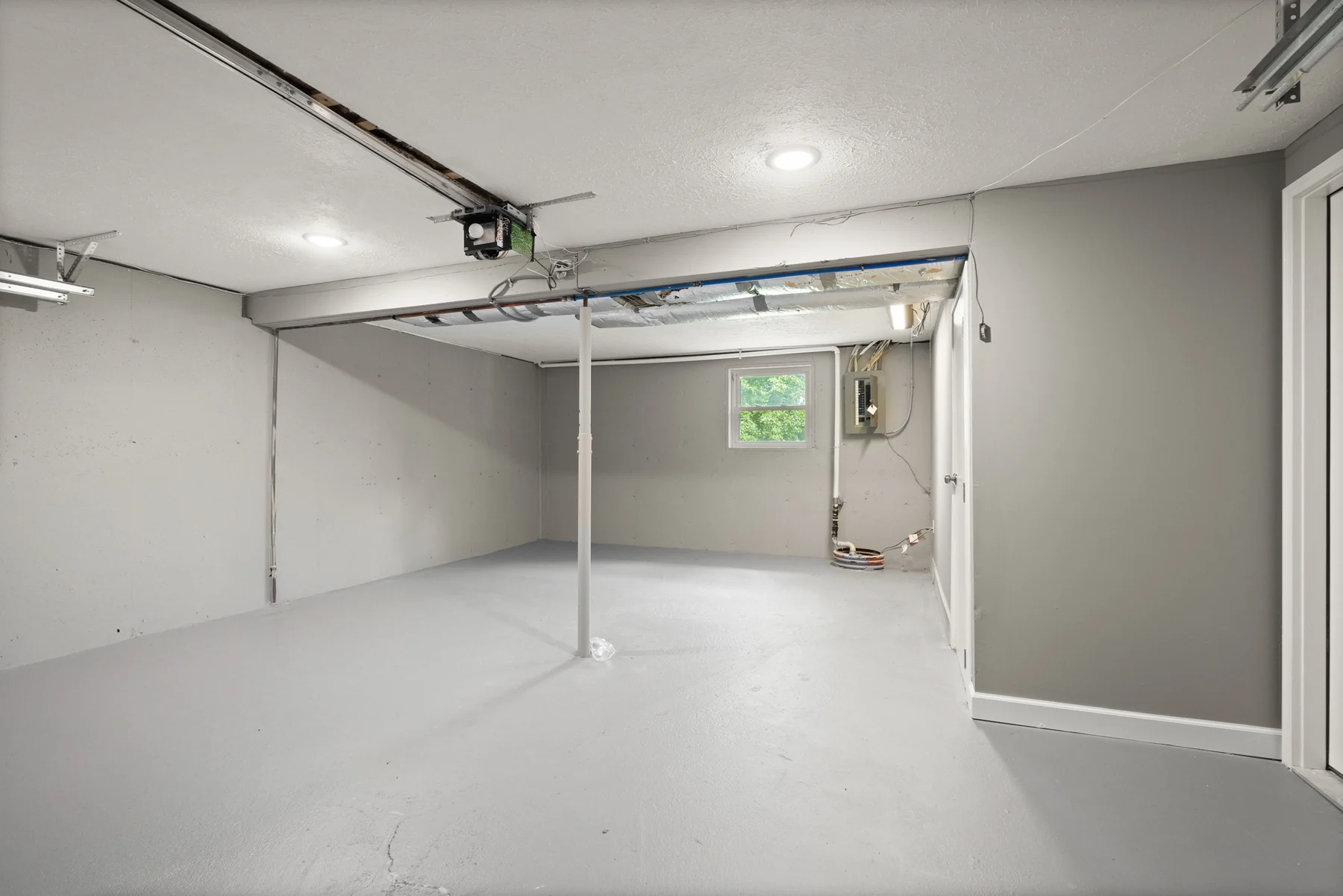 Clean attached two-car garage with finished walls and utility access