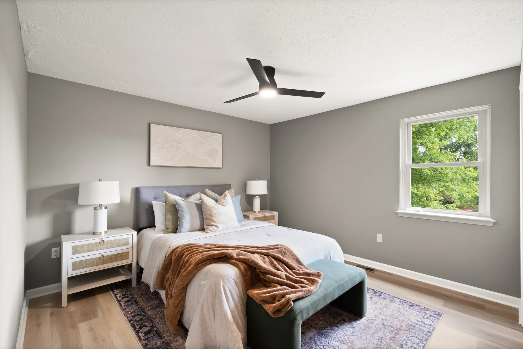 Primary bedroom with neutral walls, wood-look flooring, and modern ceiling fan