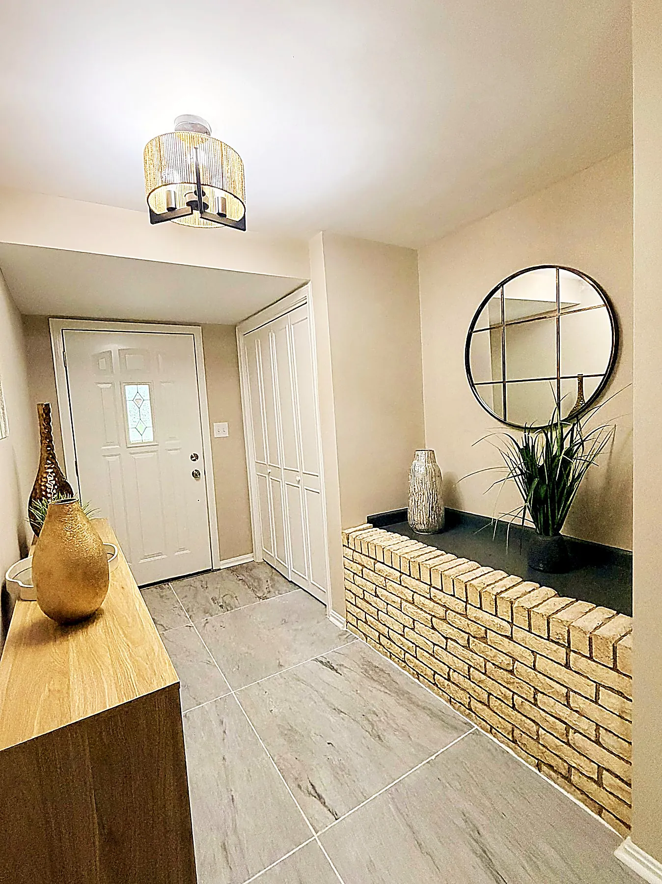 Entry foyer with a brick accent wall and tile flooring