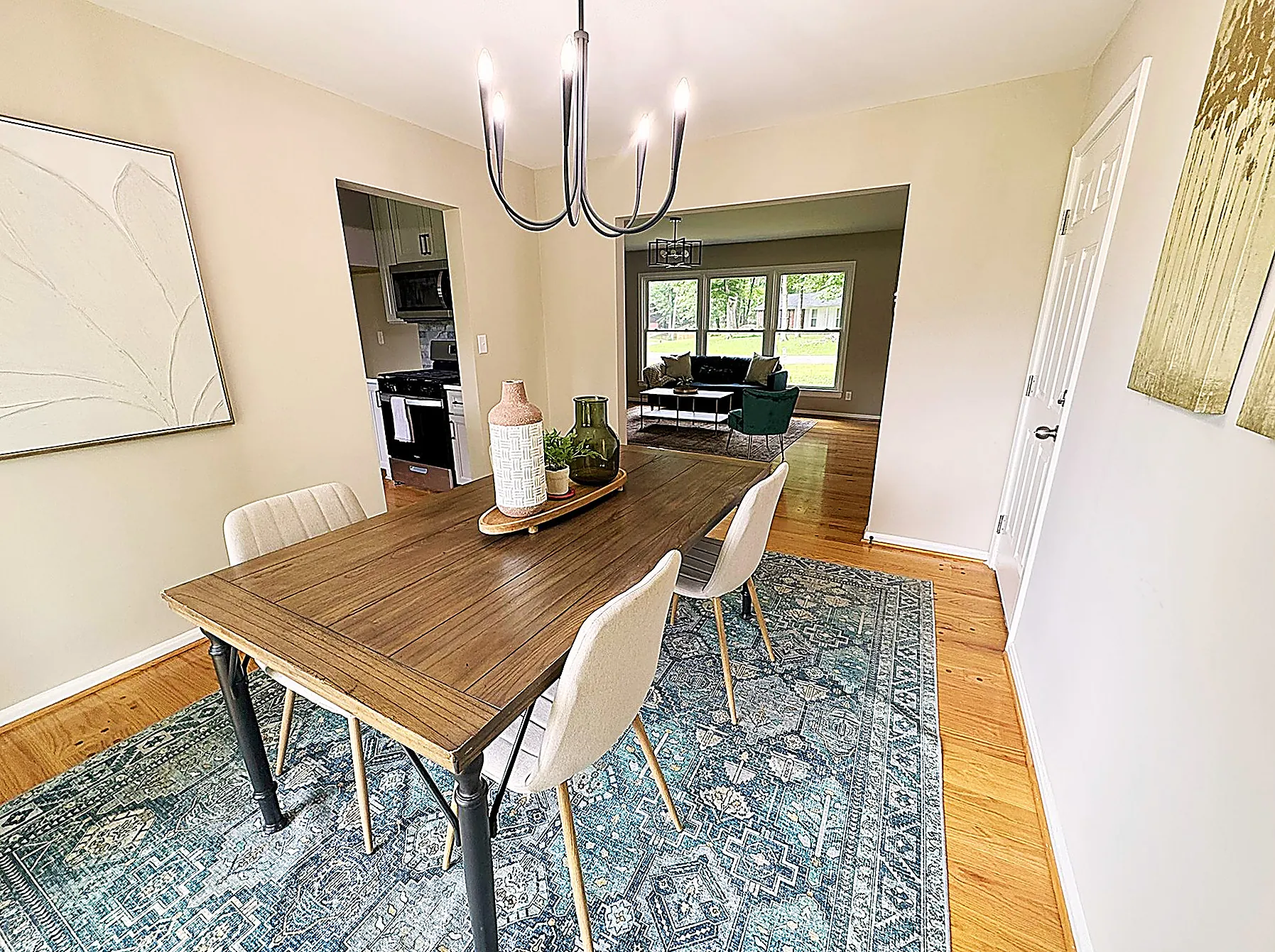 Formal dining room with a wood table, blue rug, and chandelier