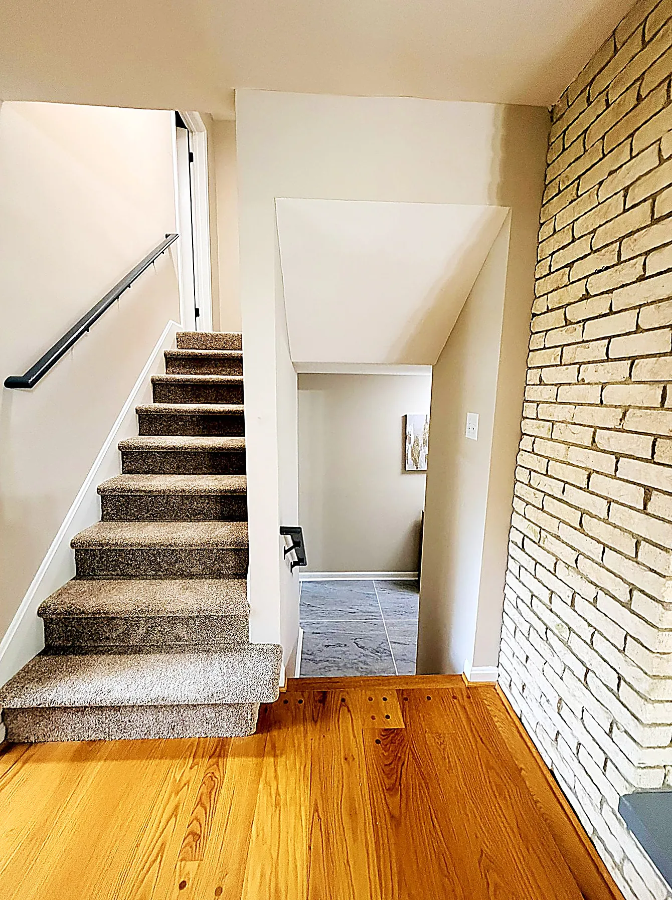 Open staircase beside a brick wall