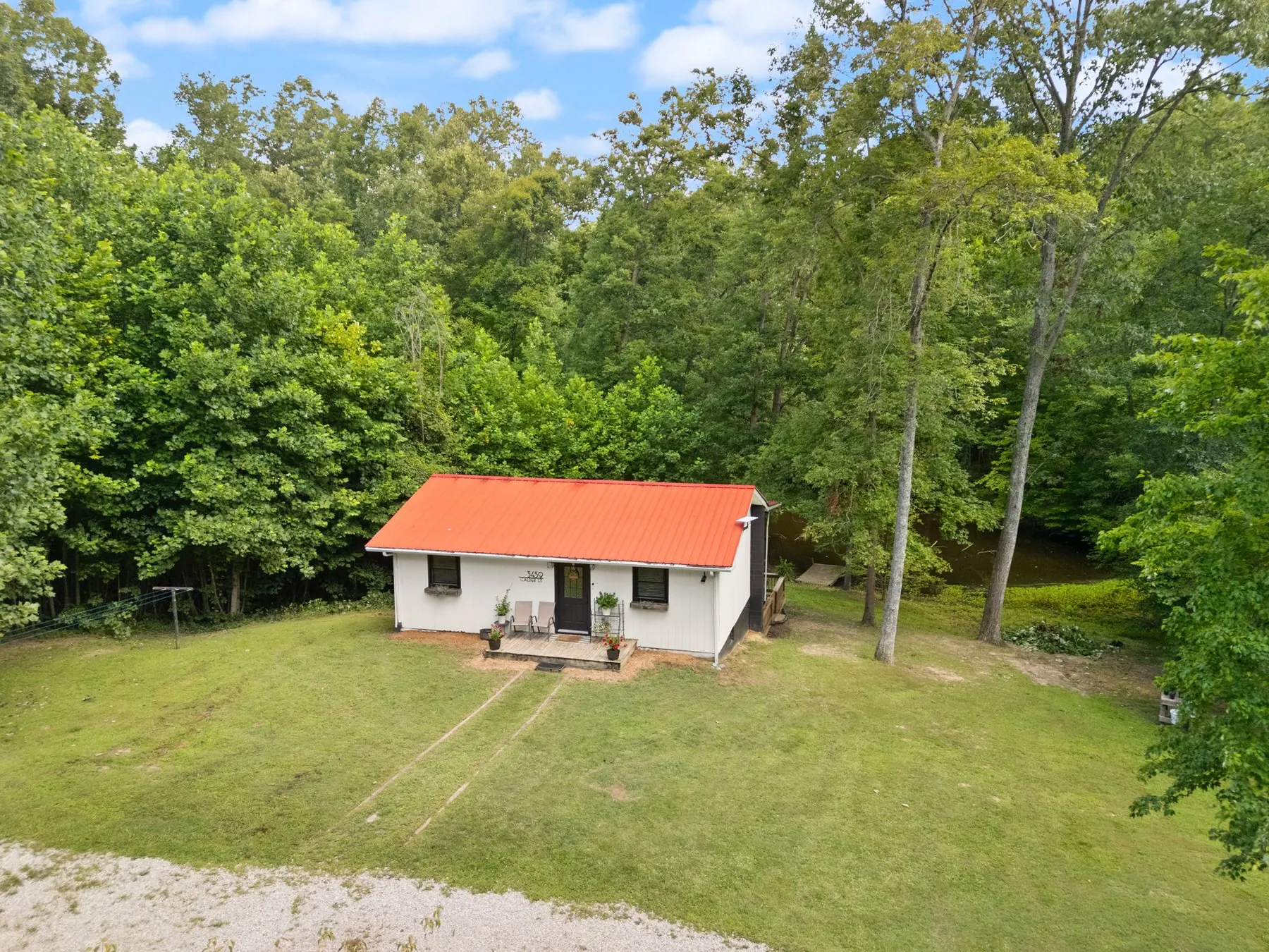 Aerial — the house and its clearing in the tree canopy