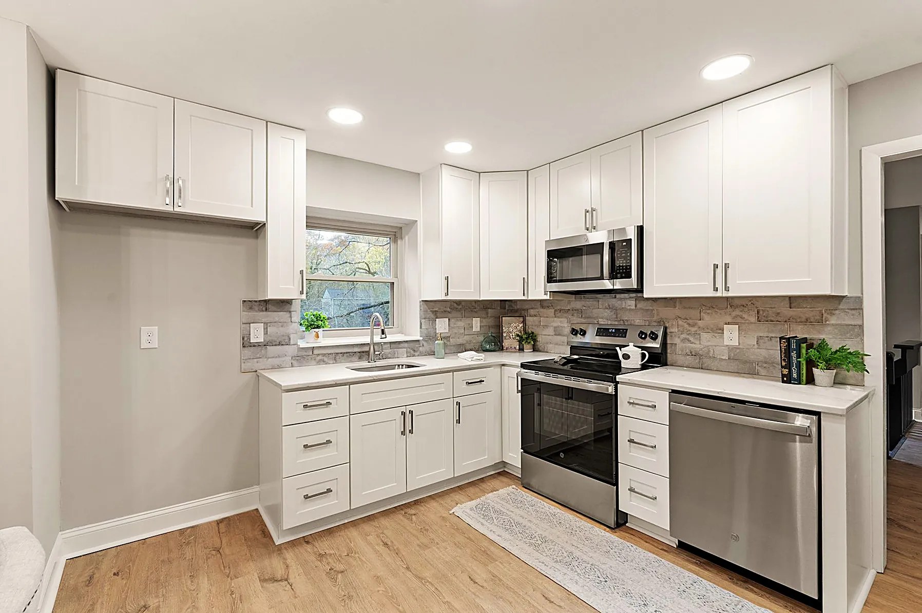 Wide view of the updated kitchen with granite counters, breakfast nook, and a sightline through to the dining area