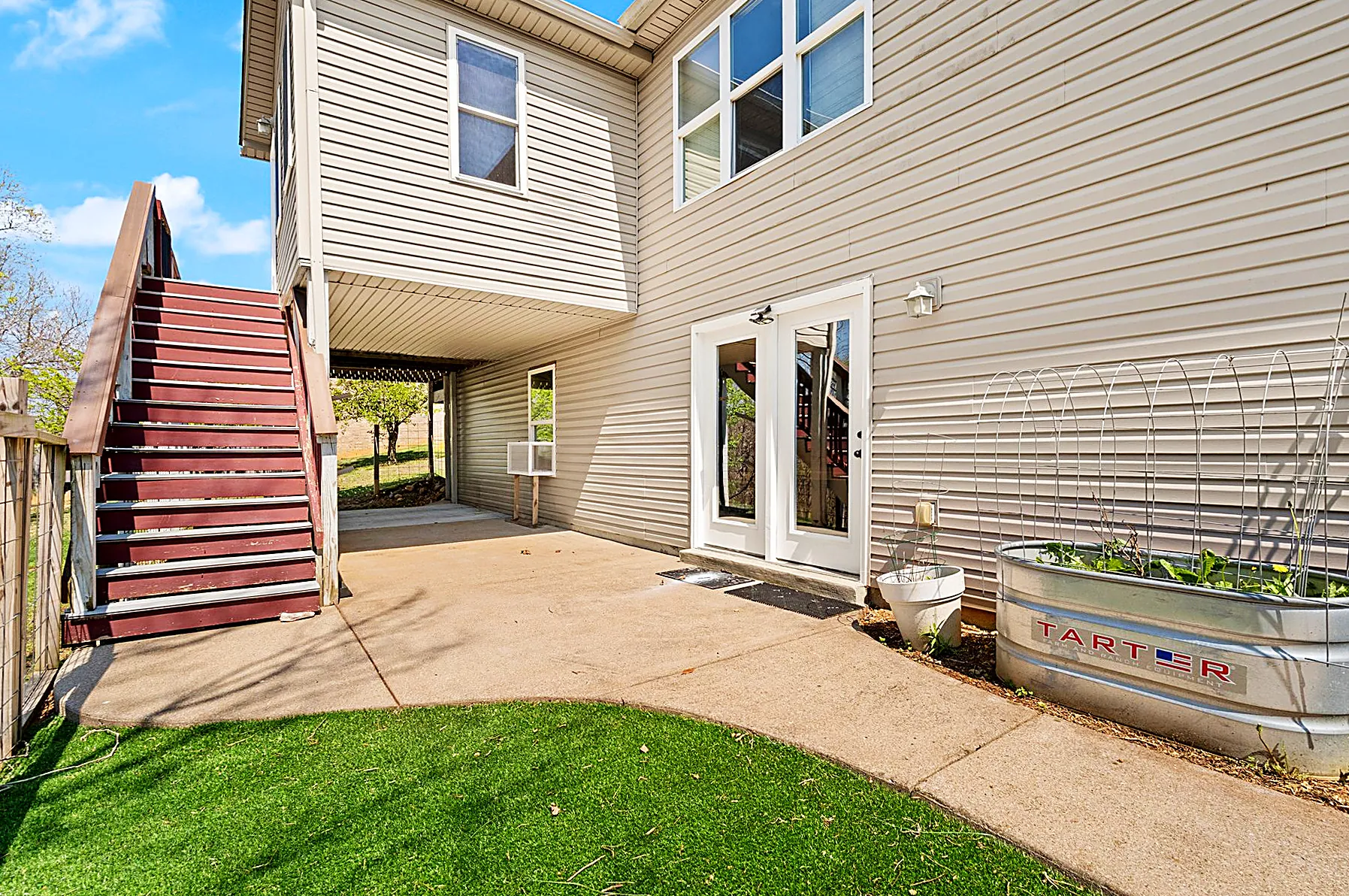 Rear patio beneath the elevated deck, opening to the backyard