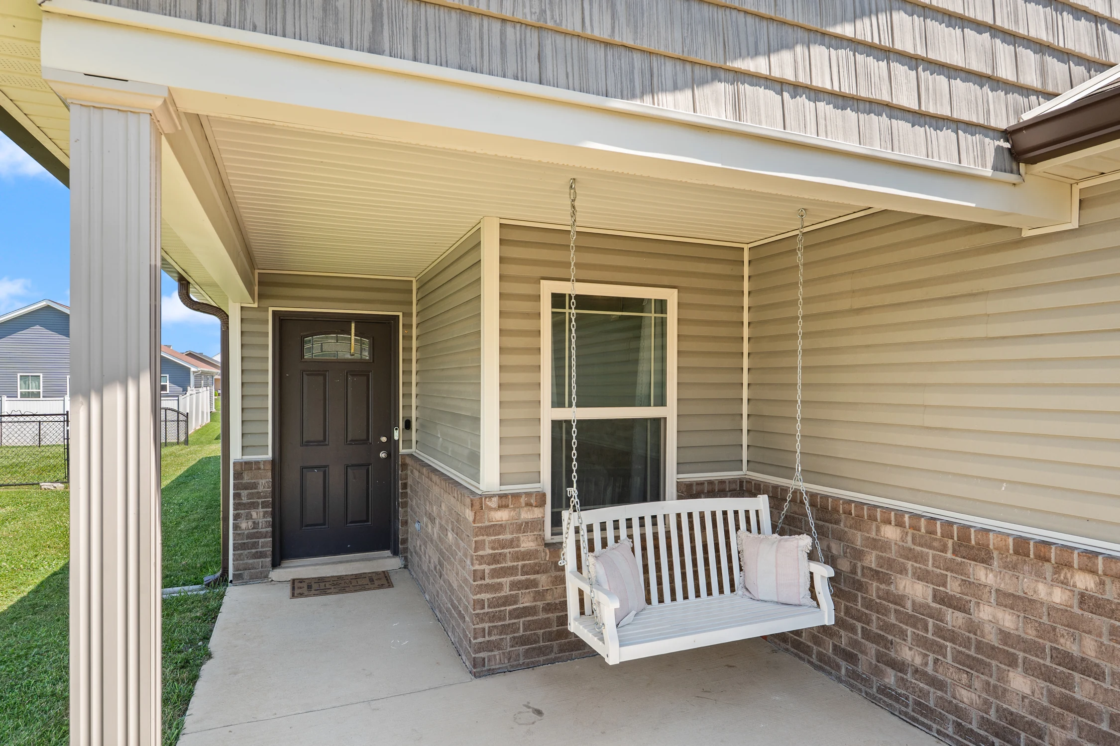 Covered front porch with hanging swing at 8002 Kismet Drive