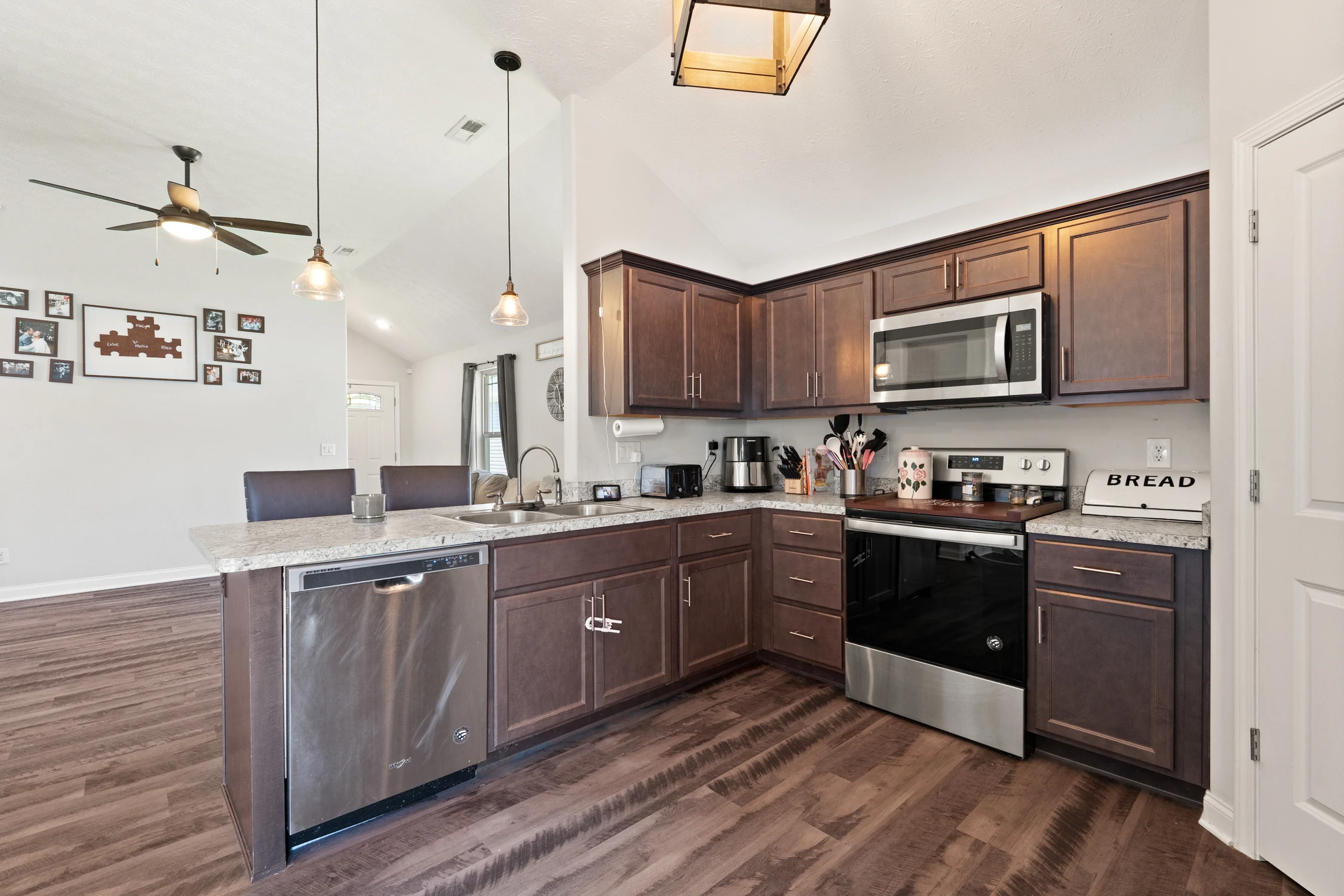 Dark cabinetry, stainless appliances, and pantry in the kitchen