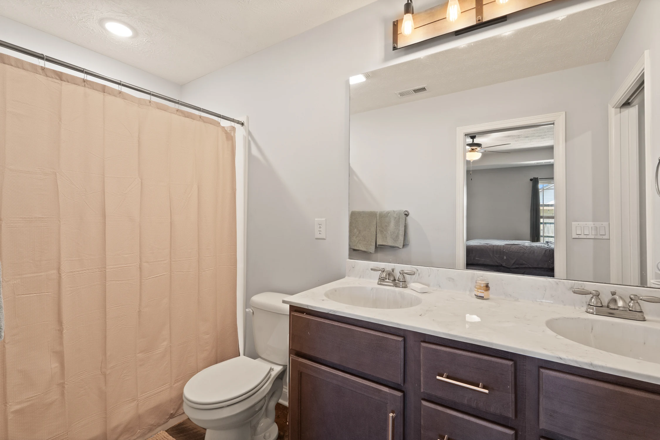 Primary bathroom with wood vanity and tub-shower combination