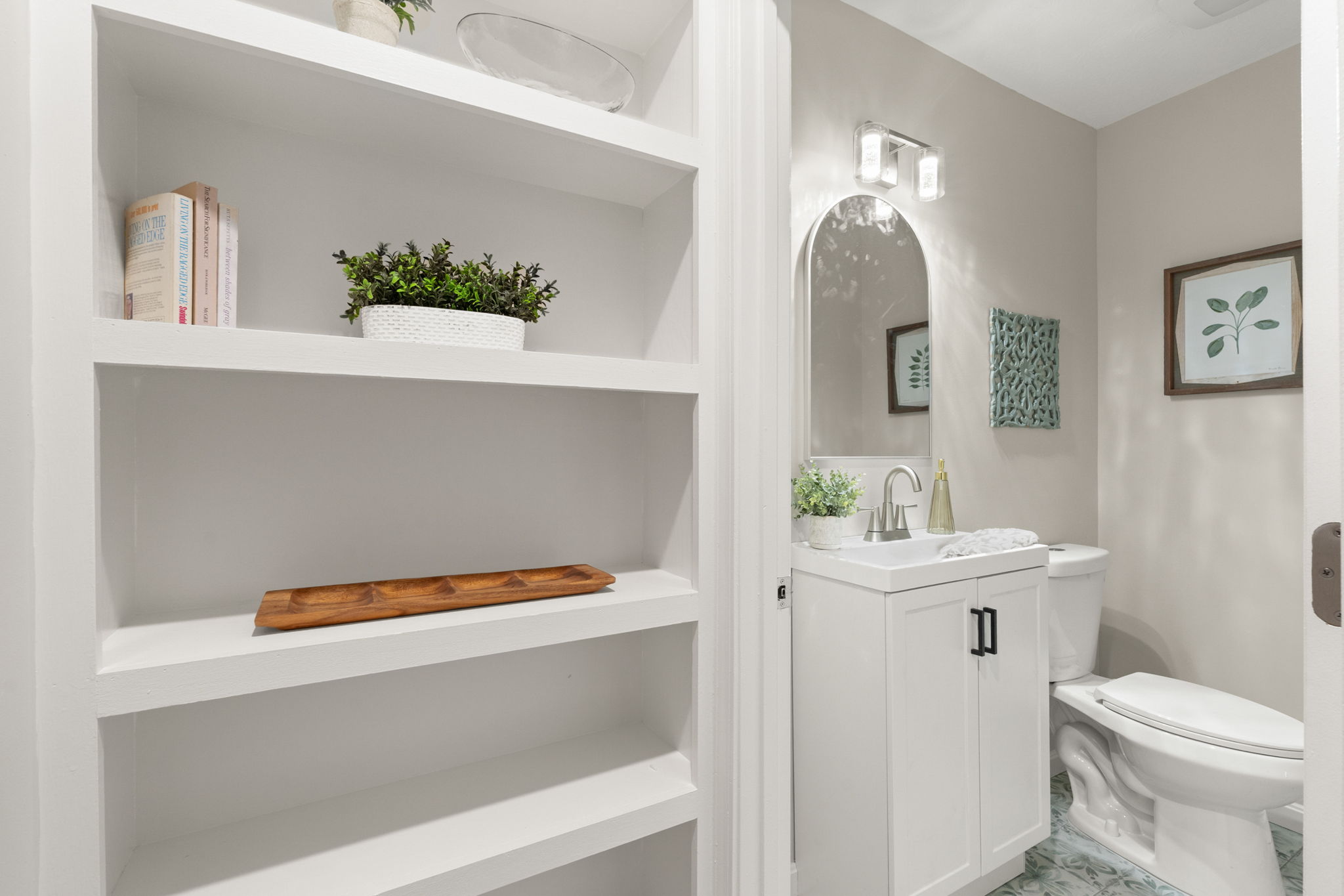 Built-in hallway shelving, half bath with arched mirror
