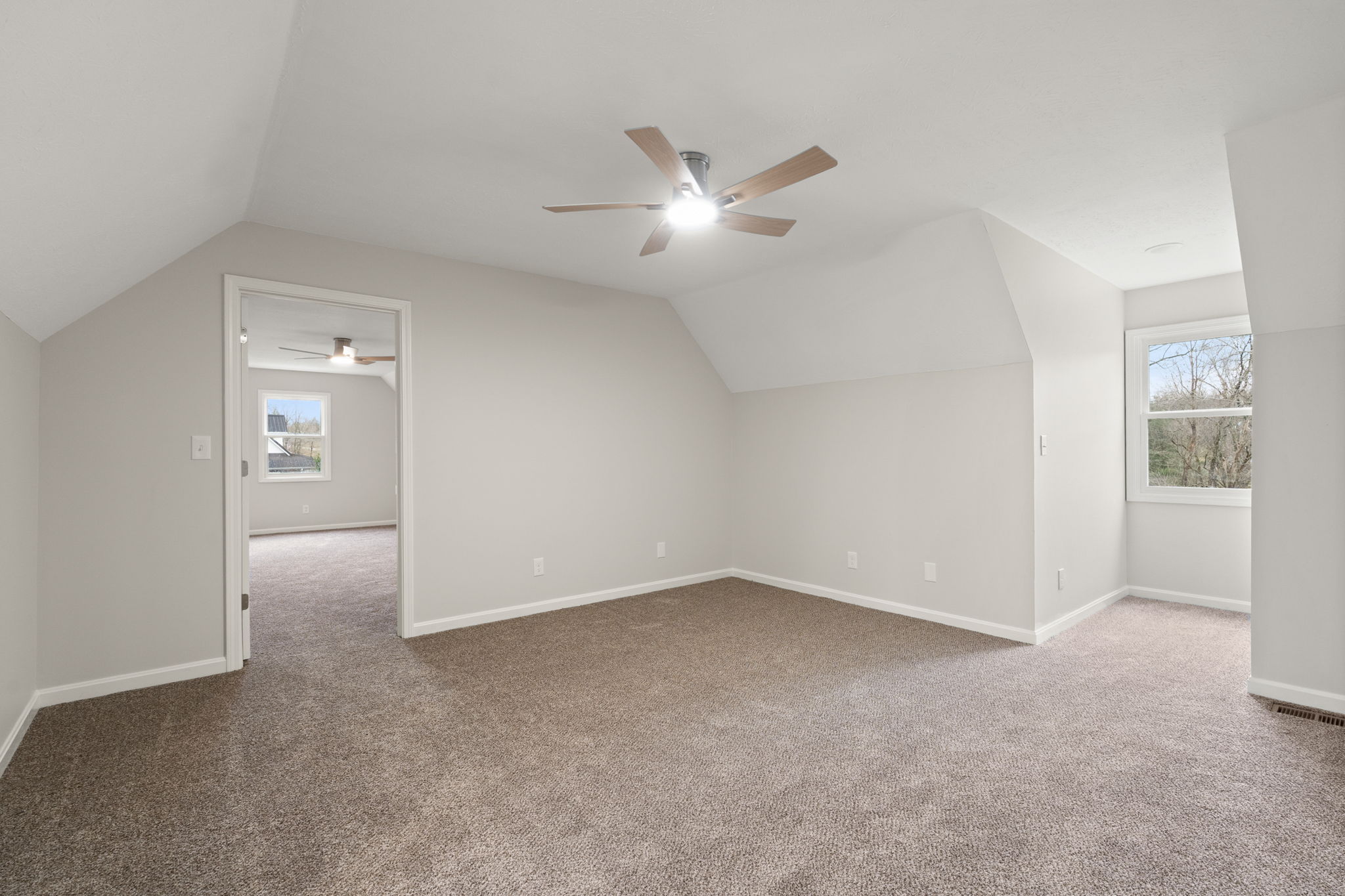 Upstairs bedroom with natural light and wooded views